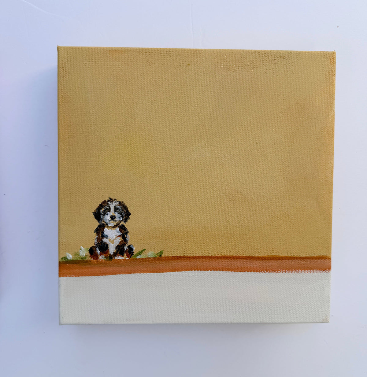 A small puppy sits on a brown ledge against a tan background in this original acrylic dog painting.