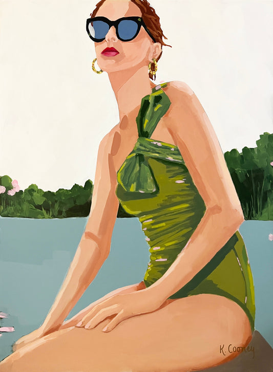 A woman in sunglasses and a green swimsuit sits by the water—original art from Kristin Cooney Studio.