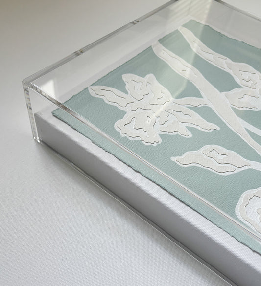 Framed botanical collage by Kendal Blanchard Art with white floral patterns on cotton rag in a clear acrylic box frame.