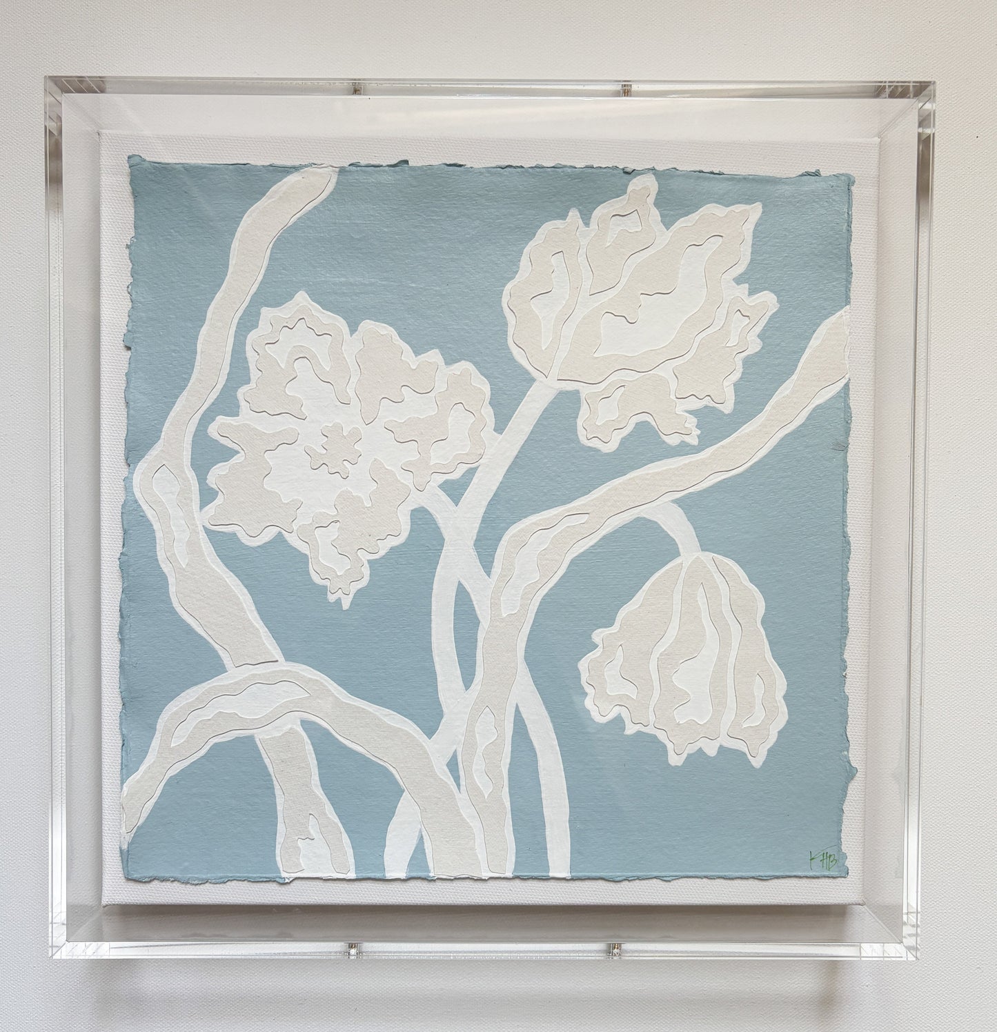 A botanical collage of white flowers on light blue, framed in acrylic by Kendal Blanchard Art.