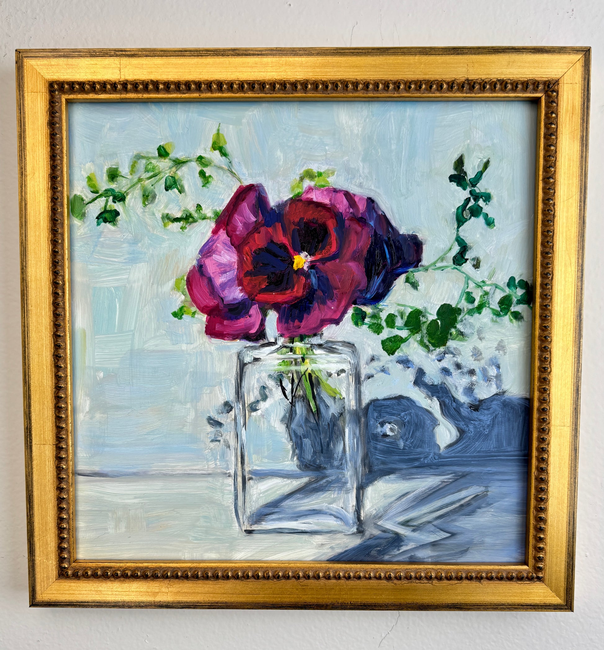 Catherine Husek framed wall art with vibrant pink flowers in a glass vase and green leaves on a light blue background.