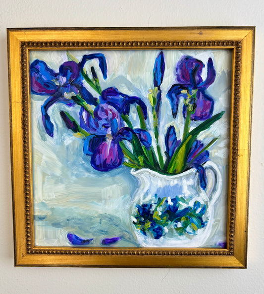 Catherine Husek Mother’s Day framed art features purple irises in a white vase with scattered petals on a light background.