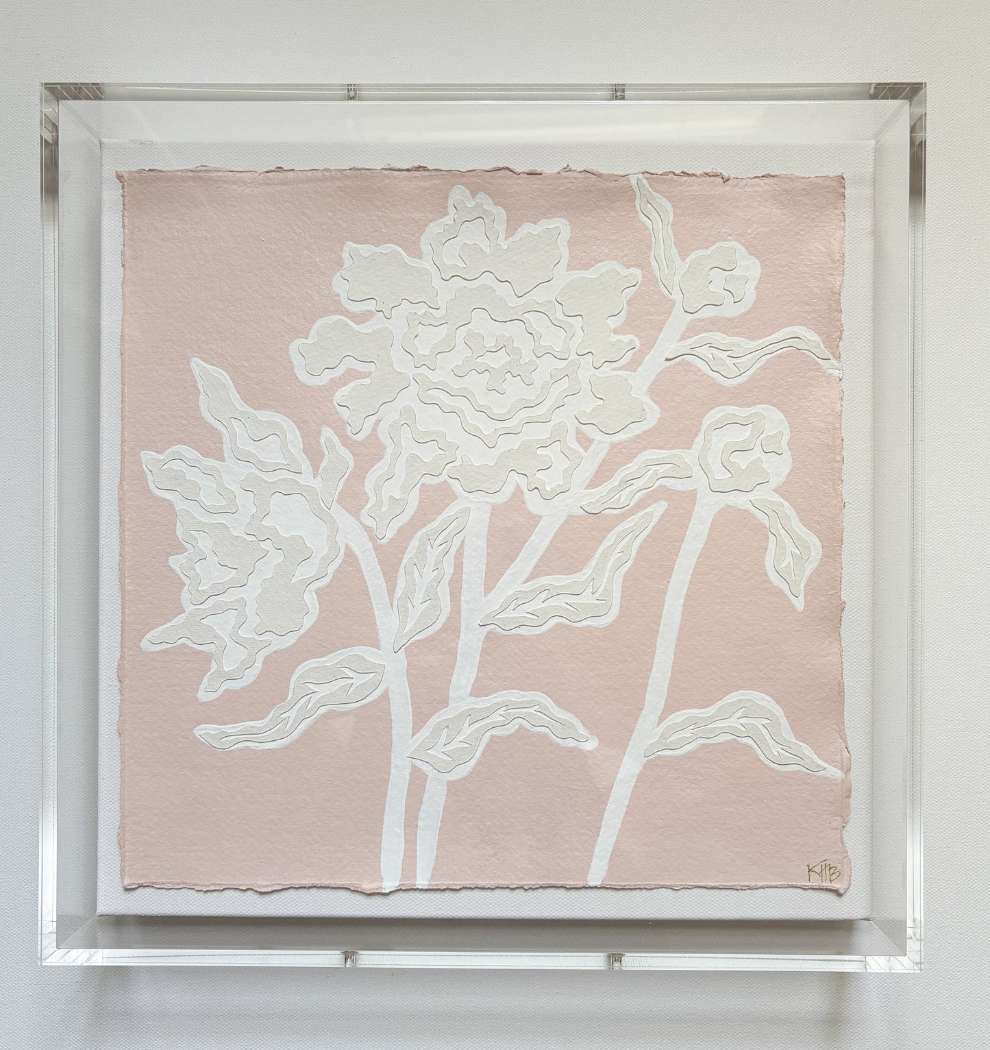 Kendal Blanchard Art: Textured white floral design on pink cotton rag paper, in a clear acrylic box frame with abstract leaves.