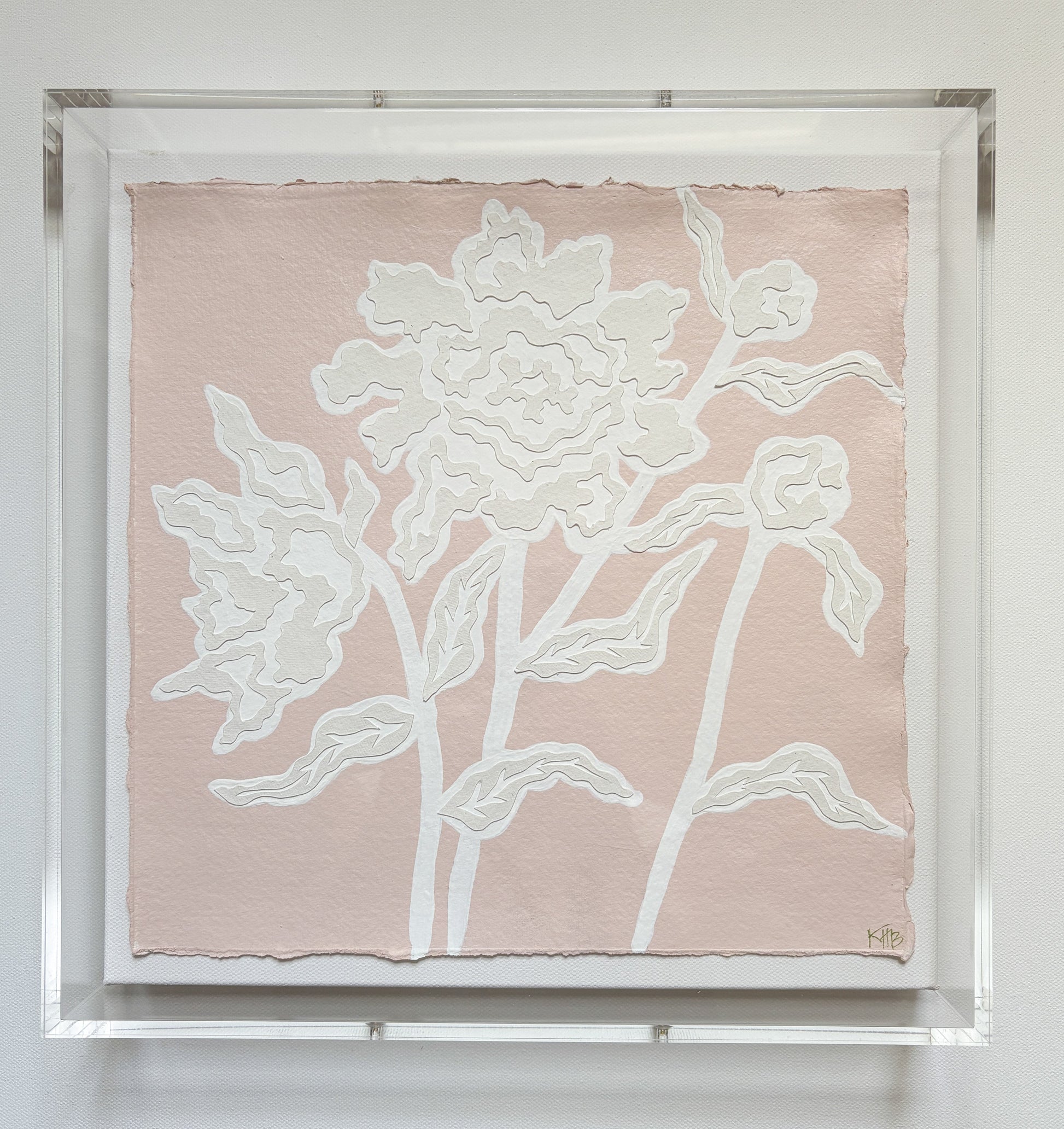 Kendal Blanchard Art: Textured white floral design on pink cotton rag paper, in a clear acrylic box frame with abstract leaves.