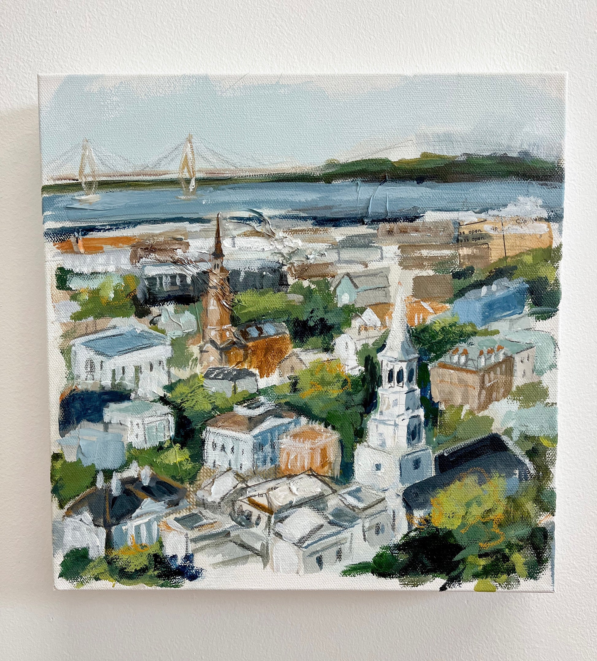 Christy Holmes 12x12 acrylic canvas of Charlestons cityscape with churches, houses, greenery, and a distant bridge.