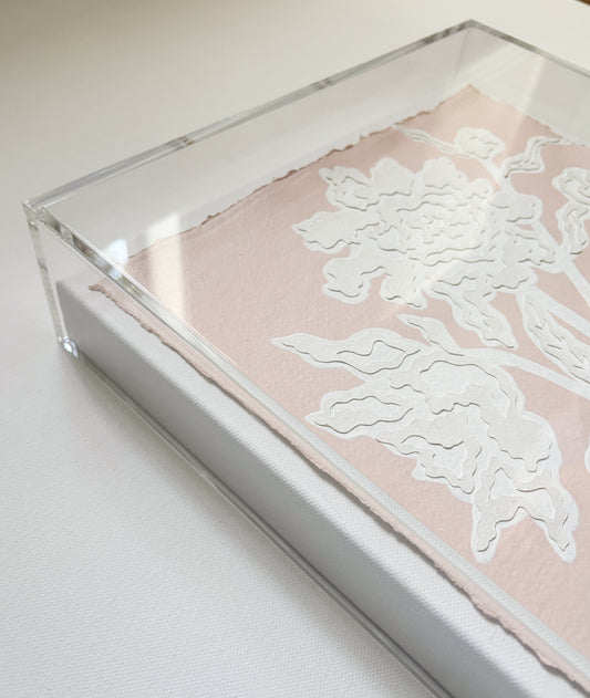 A white floral botanical collage by Kendal Blanchard Art on cotton rag paper in an acrylic box frame, white surface.