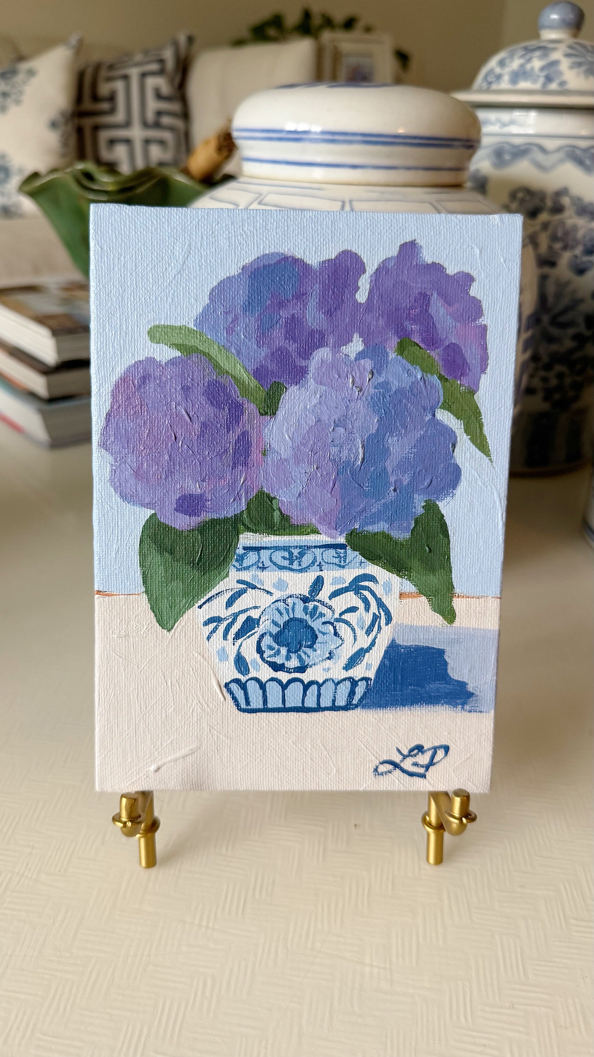 Lauri Prins original acrylic painting of purple flowers in a blue and white vase, ideal for floral home decor.