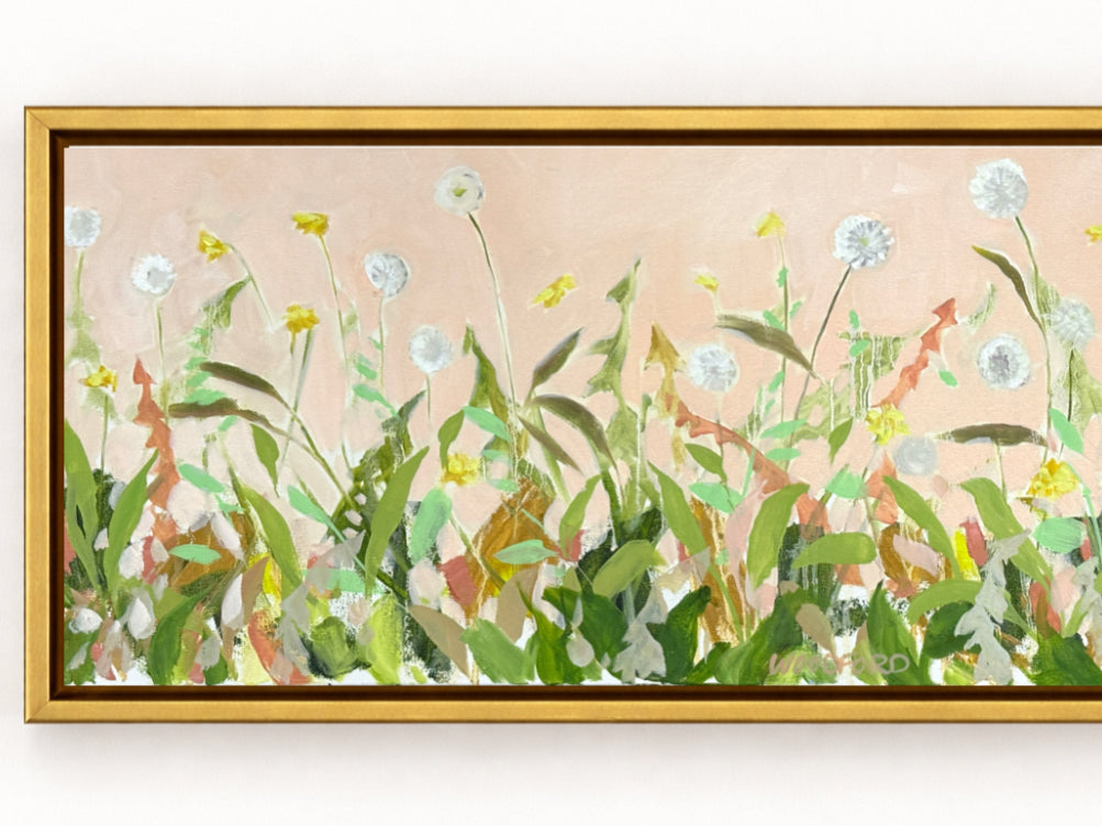 Shannon Woodford’s framed painting features modern dandelion floral art and green grass on a light pink background.