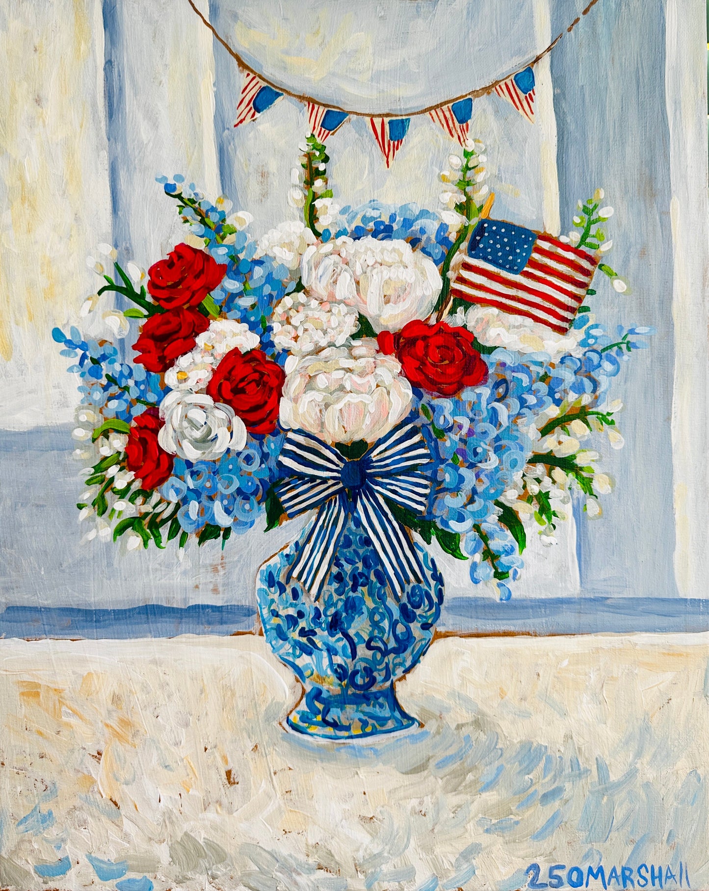 A Lauren Marshall Fine Art blue vase with patriotic flowers, bow, and flag—ideal Fourth of July decor.