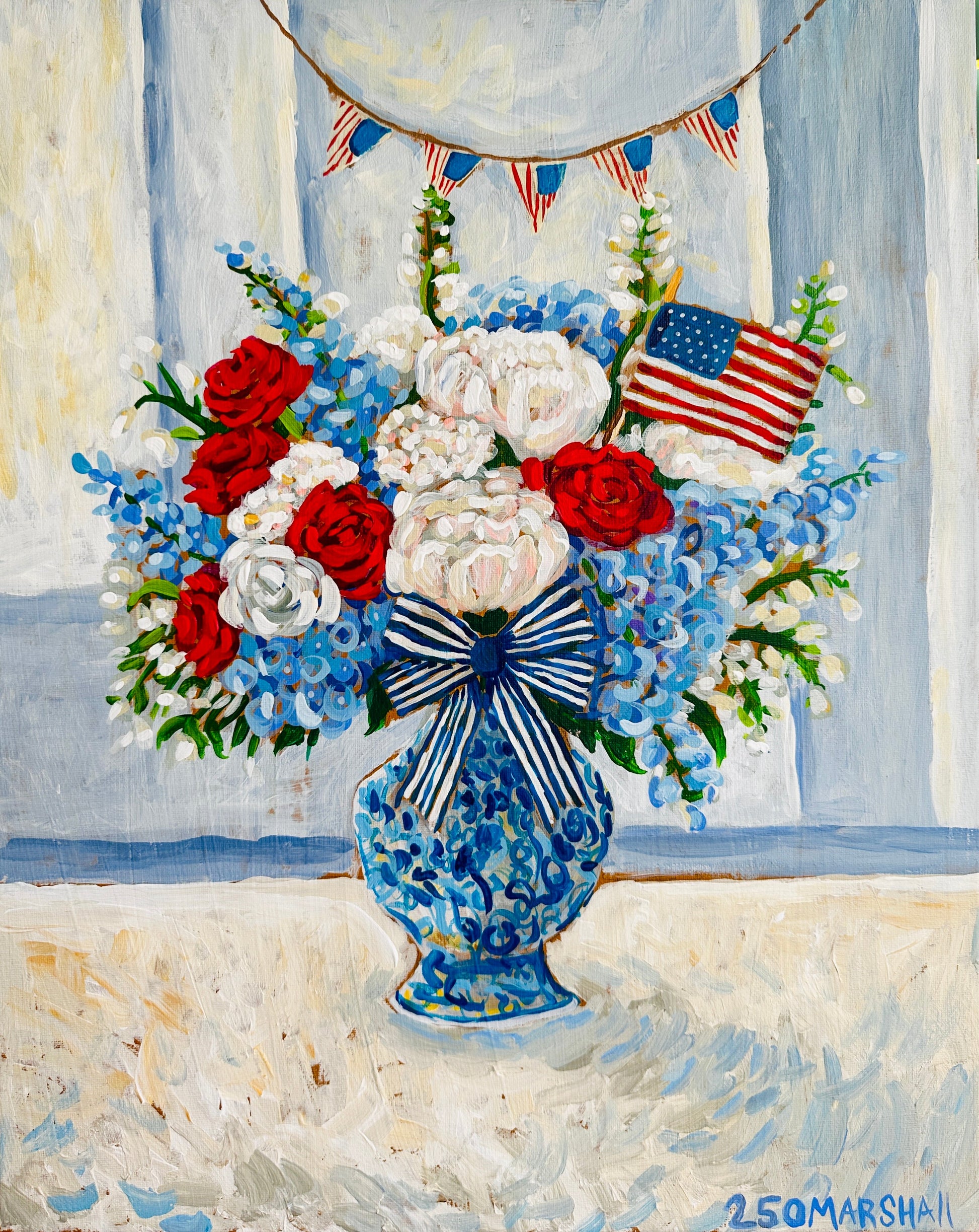 A Lauren Marshall Fine Art blue vase with patriotic flowers, bow, and flag—ideal Fourth of July decor.