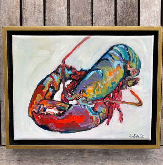 Catherine Husek’s vibrant lobster art in a gold float frame pops against a wooden background for bold wall decor.