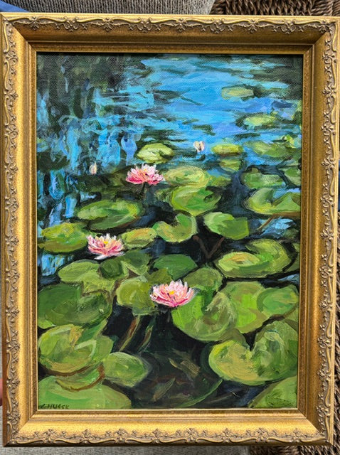 Catherine Husek framed art of pink water lilies and lily pads floating on a blue pond in a vintage gold frame.