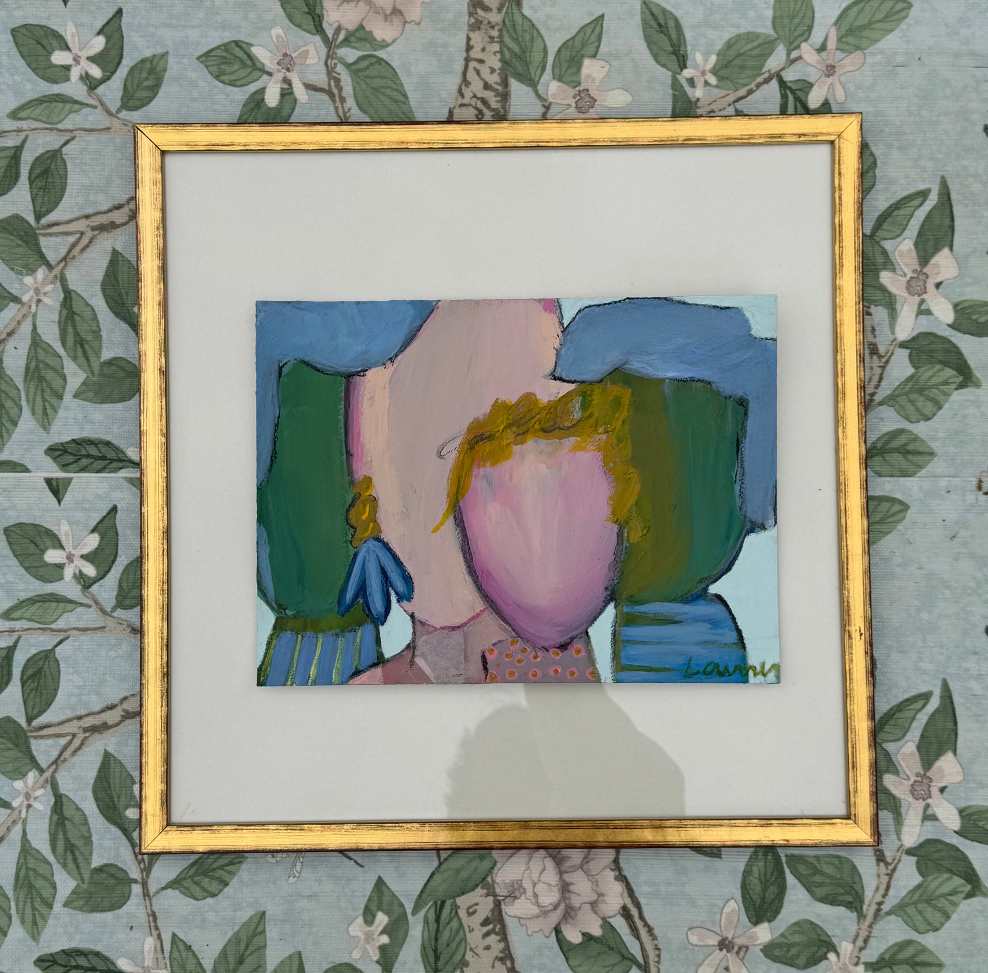 KP Art Collective framed mixed media art of a faceless figure with green shapes and floral wallpaper background.
