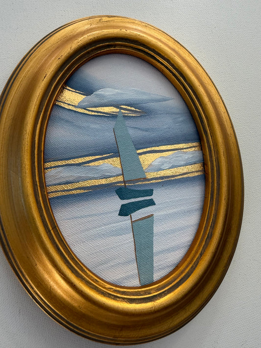 An oval Nikki Storer painting in a gold frame depicts an abstract blue and goldleaf landscape with clouds and a monolith.