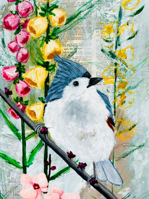 A painted bird with blue head and white body perches on a branch in an imagined garden painting among pink flowers.