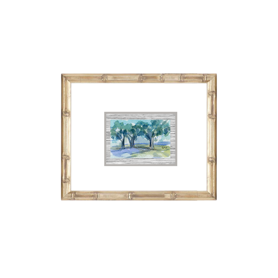 A small Elizabeth Sheats Art & Design watercolor of trees in a light wood frame with a white mat.